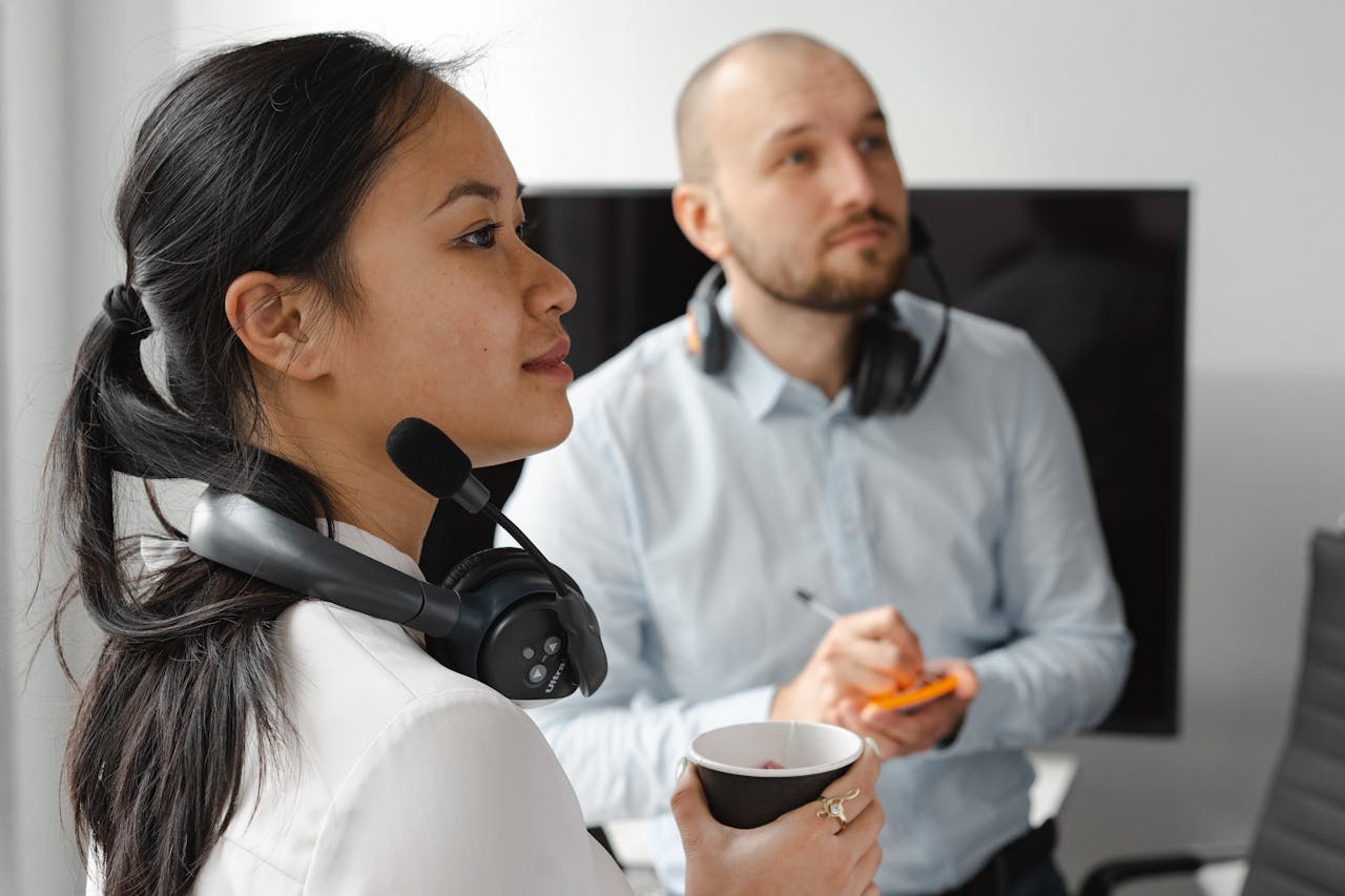 gallery-4 Two call center agents with headsets working in an office environment, focusing on customer support tasks.