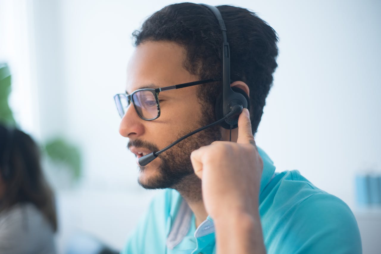 services-02 Focused young male professional wearing headset in call center environment.